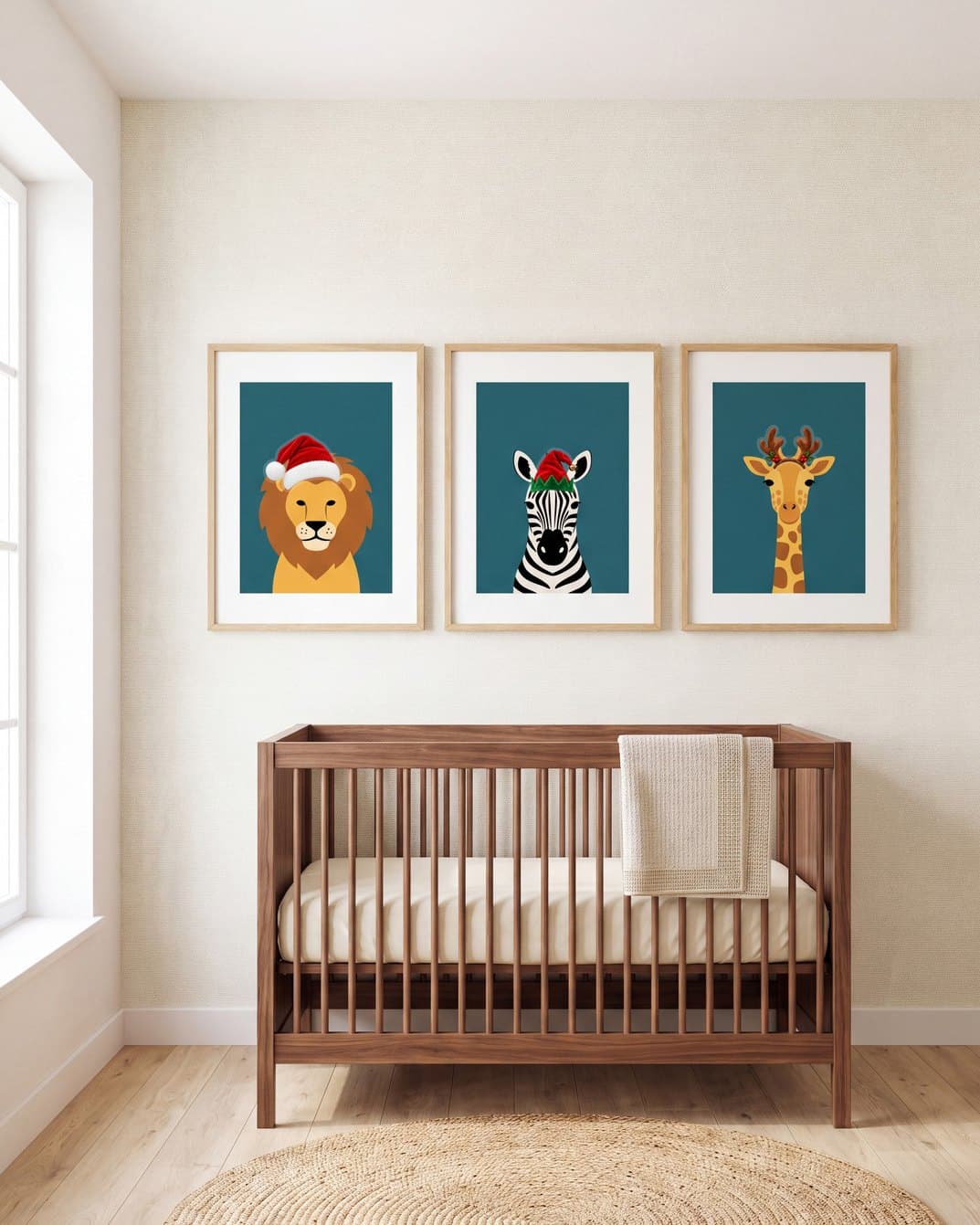 Three animal prints above a crib, a lion, a zebra and a giraffe, in a Santa hat, an elf hat and antlers
